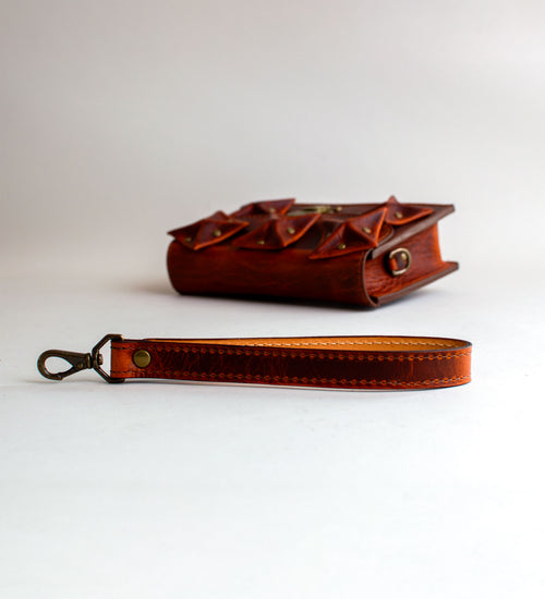Strap-View-Of-Amber-Colored-luxury-leather-handbag-with-folded-origami-leather-embellishments-handmade-in-the-us-with-brass-hardware