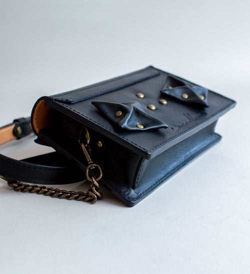 Rear-View-Of-Black-Colored-luxury-leather-handbag-with-folded-origami-leather-embellishments-handmade-in-the-us-with-brass-hardware