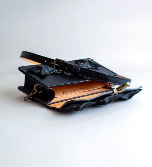 Interior-View-Of-Black-Colored-luxury-leather-handbag-with-folded-origami-leather-embellishments-handmade-in-the-us-with-brass-hardware
