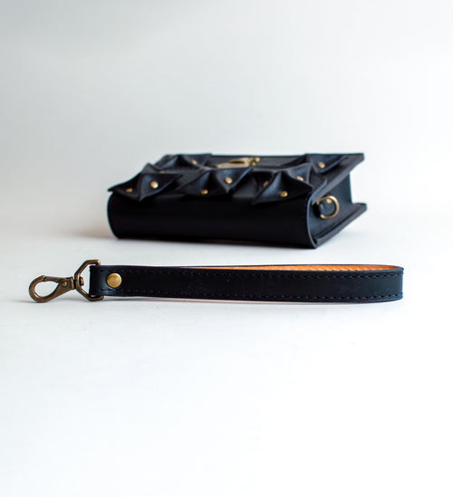 Strap-View-Of-Black-Colored-luxury-leather-handbag-with-folded-origami-leather-embellishments-handmade-in-the-us-with-brass-hardware