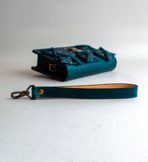 Strap-View-Of-Aquatic-green-Colored-Waxy-luxury-leather-handbag-handmade-in-the-us-with-brass-hardware-and-folded-origami-leather