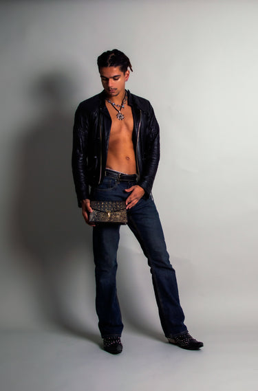 Model surrounded by luxury leather purses, Handmade in the U.S. by Duncan Maxwell