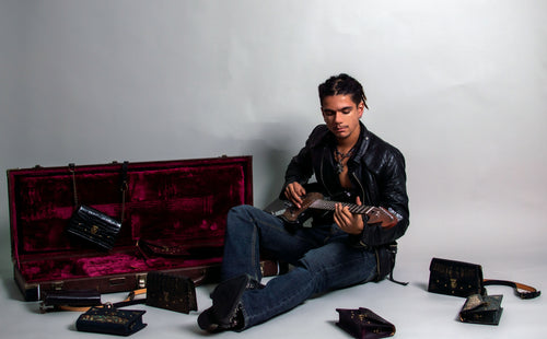 Model surrounded by luxury leather purses, Handmade in the U.S. by Duncan Maxwell