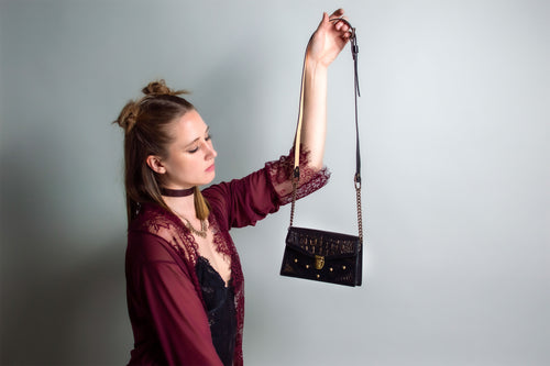 Model holding a black and bronze luxury leather purse, Handmade in the U.S. by Duncan Maxwell