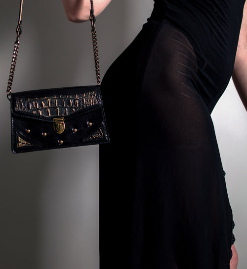 Model holding black and bronze crocodile embossed leather purse. Handmade in the U.S.