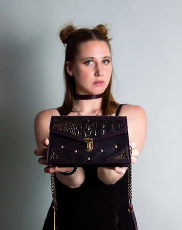 Model holding a black and bronze luxury leather purse, Handmade in the U.S. by Duncan Maxwell