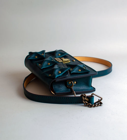 Side-View-Of-Aquatic-green-Colored-Waxy-luxury-leather-handbag-handmade-in-the-us-with-brass-hardware-and-folded-origami-leather