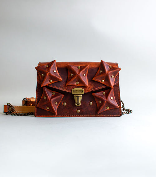 front-View-Of-Amber-Colored-luxury-leather-handbag-with-folded-origami-leather-embellishments-handmade-in-the-us-with-brass-hardware