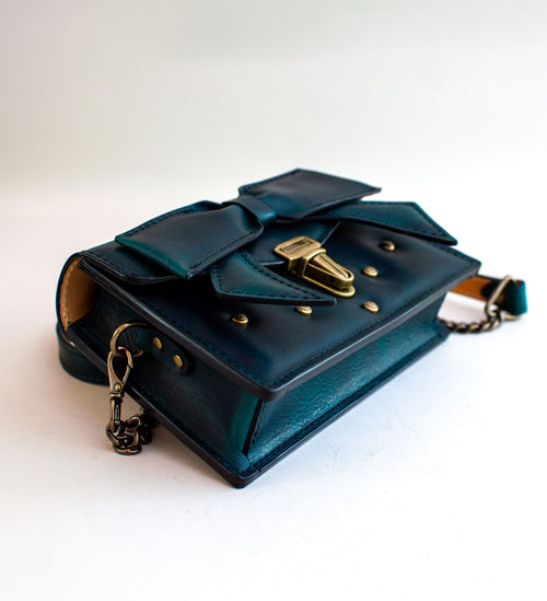 three-quarter-view-of-handmade-luxury-leather-purse-with-padding-and-folded-leather-bow-featuring-antique-brass-hardware-by-Duncan-Maxwell