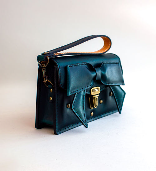 Side-view-of-handmade-luxury-leather-purse-with-padding-and-folded-leather-bow-featuring-antique-brass-hardware-by-Duncan-Maxwell