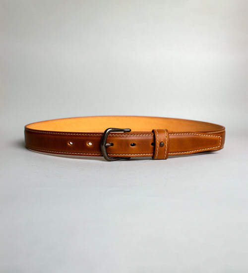 Light Brown handmade leather belt with antique brass buckle on a light gray background