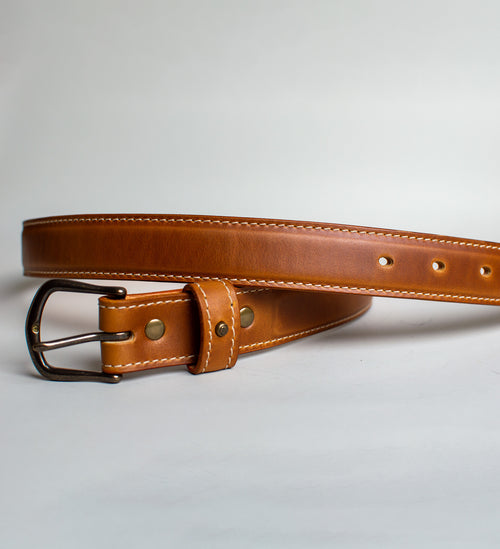 Light Brown handmade leather belt with antique brass buckle on a light gray background
