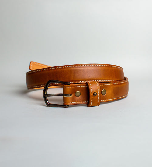 Light Brown handmade leather belt with antique brass buckle on a light gray background